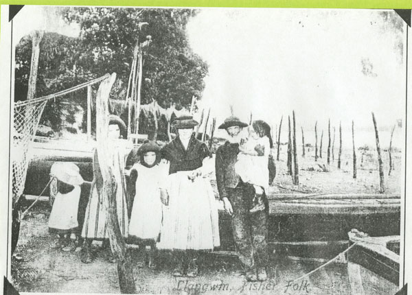 Copy of a photograph of Llangwm Pembrokeshire Fisherfolk on the River Cleddau foreshore showing the drying nets behind. The photograph is labelled Llangwm Fisher Folk